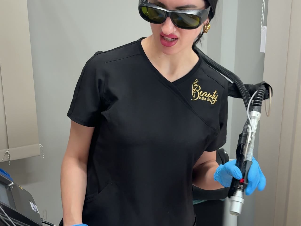A Beauty in the City therapist operating the laser in protective eyewear
